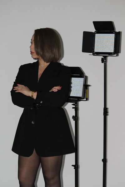 Bri Davis, Founder of Allure Atelier, looking to the left with studio lights to her right in the background