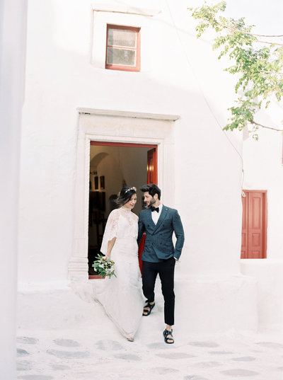 a bride and groom leaving their ceremony at their wedding in Mykonos, Greece