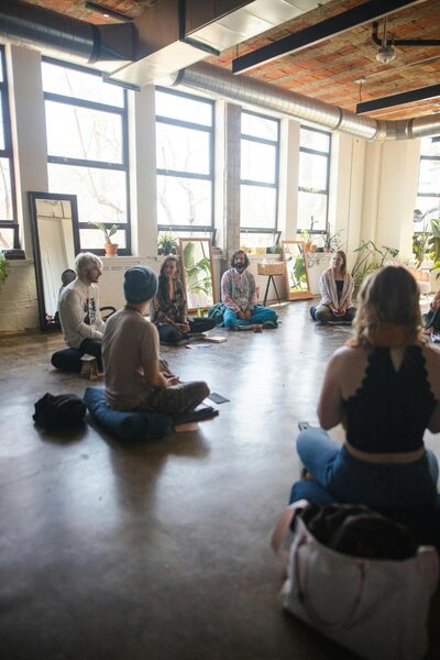 A group sitting on the ground in community with one another