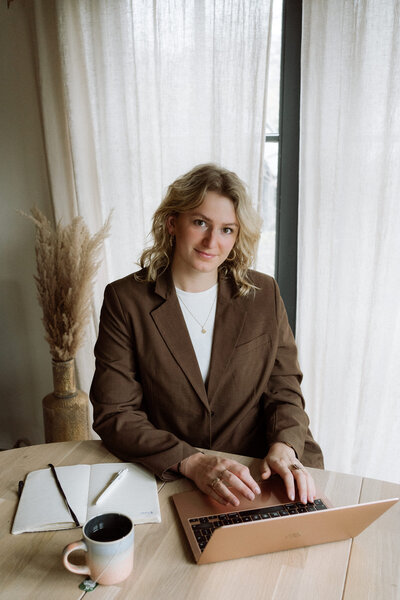 Branding shoot binnen - Roos zit achter de laptop. 