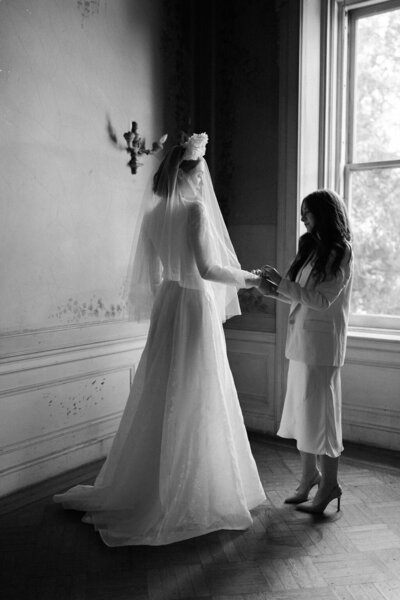 wedding dress designer adjusting bride's wedding dress