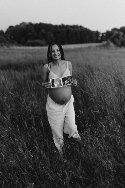 en fotograf iklädd en vacker vit klänning går ute i öknen med ett stort leende