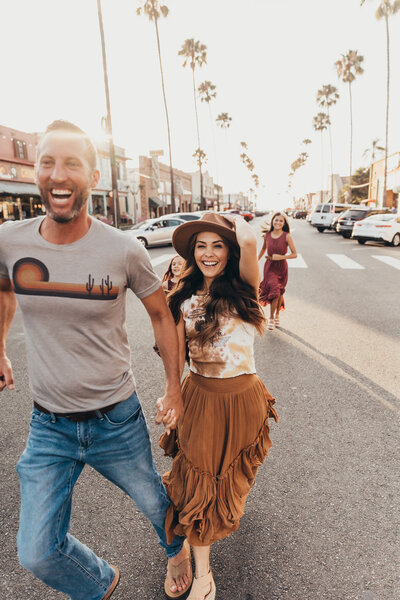 A family runs down a palm tree lined street in San Diego's Ocean beach neighborhood
