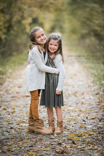 young sisters hugging on walking trail