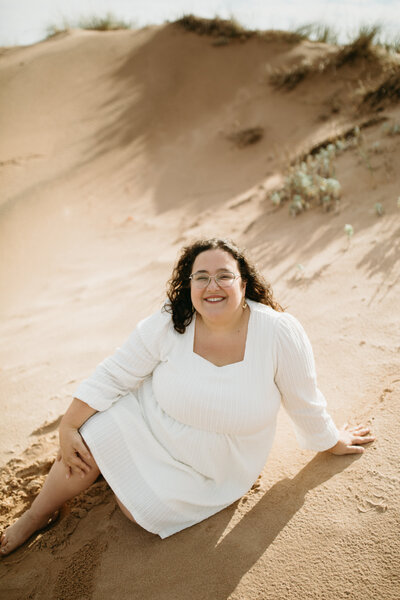 Wedding, engagement, and couple photographer, Valerie Doucette, posing in the sand at the beach