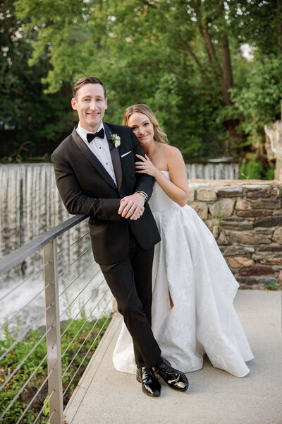 Black and white image of bride resting head on groom's shoulder