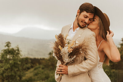 Couple sharing a kiss surrounded by blooming flowers