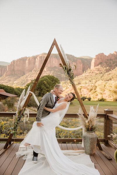 Couple poses for a photo after getting married in front of red rocks in Basalt, Colorado