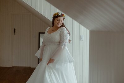 bride twirls her dress in an attic room