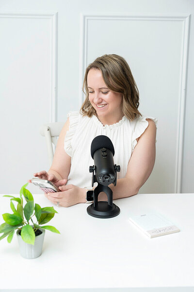 action photo of a social media manager holding a phone in Annapolis studio for her personal branding photoshoot
