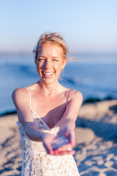 Woman at beach offering hand full of gems
