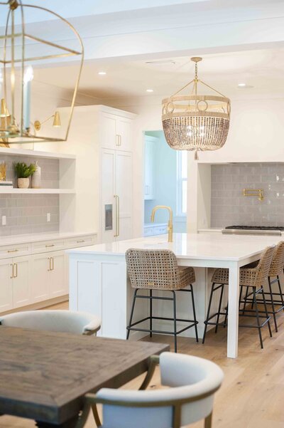 white kitchen with large lamp and chairs