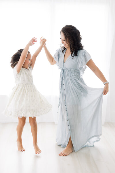 mom and daughter dancing during Houston photo session at Grace & Giggles Studio