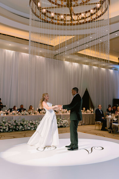 A couple in wedding attire, the bride in a gown and the groom in a blue tux, share a first look inside the Washington Hotel in Washington DC. The photo was taken by Get Ready Photo.