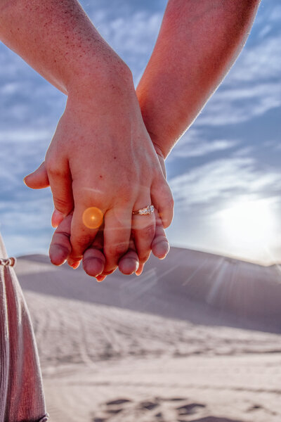 couple shows off engagement ring in yuma sand dunes