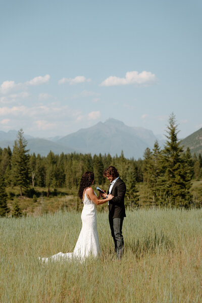 An adventure elopement couple securing their wedding bouquet to their hiking backpack.