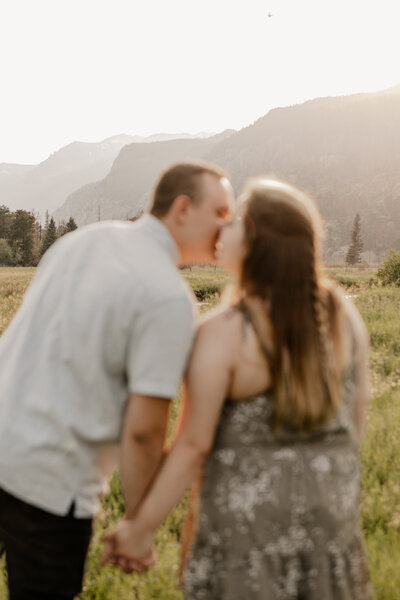 Couple kissing with their back to the camera, during an engagement session