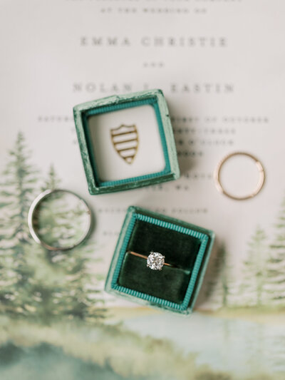Close up photo of a solitaire engagement ring in a green vintage velvet ring box
