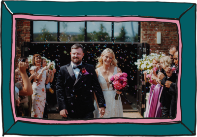 Bride and groom walking through people blowing bubbles with big smiles on their faces