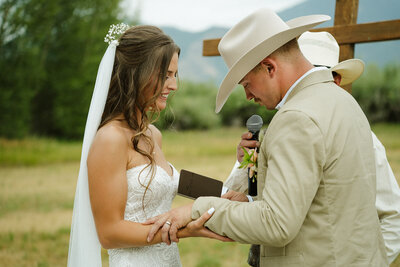 Eastern Idaho Wedding and elopement photograher, photography session. A bride and groom are at the alter, in an outdoor setting, with the groom reading his vows to the bride.