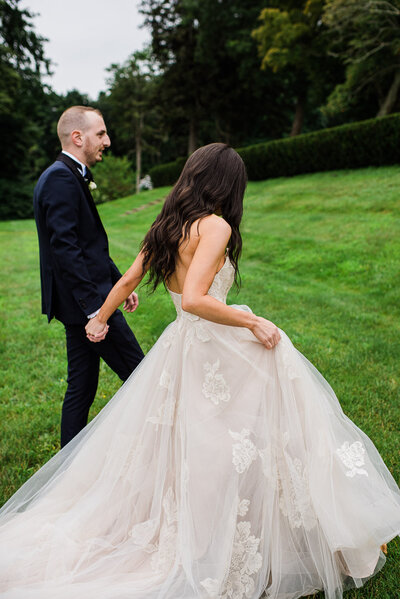 bride and groom walk away on lawn