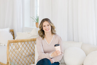 Life coach for moms smiling at the camera in white living room