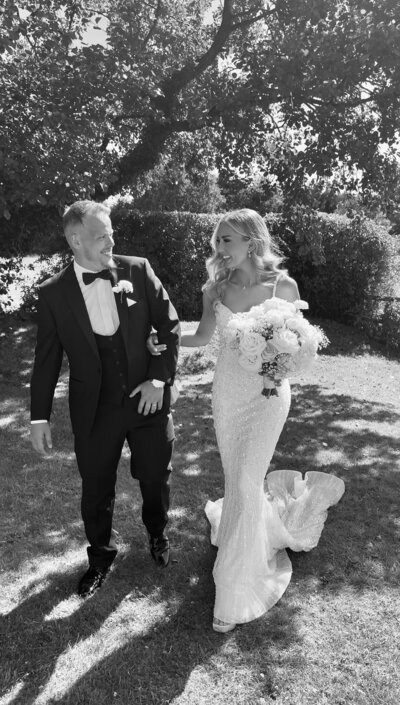 Summer bride and groom laughing with each other 