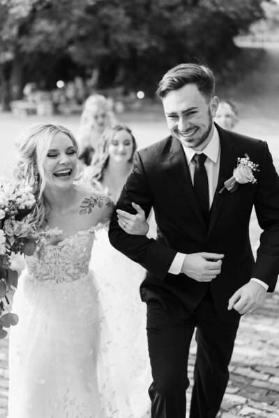 A bride and groom laugh as they exit their wedding ceremony