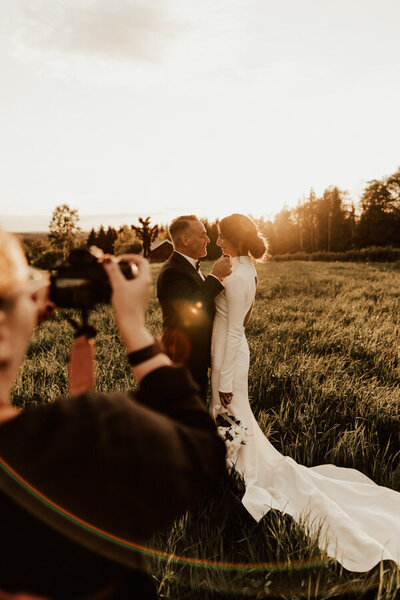 wedding couple posing while wedding photographer shoots golden hour portraits at uddetorp säteri