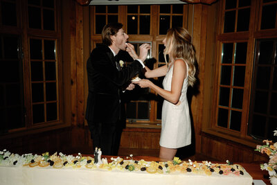The bride and groom share a playful moment as they feed each other cake—sweetness, laughter, and love served in every bite.