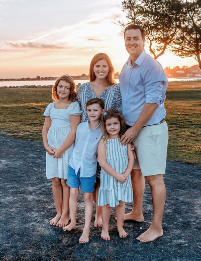 Stamford CT photographer captures beautiful family of five in blue and white coordinated outfits during golden hour waterfront session