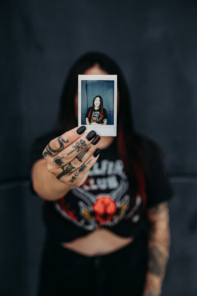 Photographer holds polaroid of self