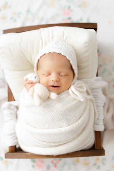 7 day old newborn boy wrapped in a blue swaddle with fingers out in a bamboo basket in Savannah, Ga