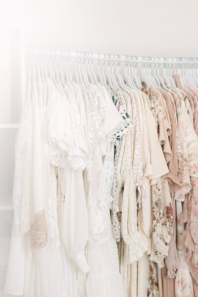 Close up detail photo of beautiful dresses hanging on white hangers in a line in a bright louisville kentucky studio
