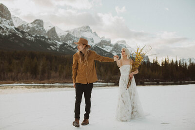 bride in elopement dress holding hands with groom