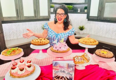 Dyana sitting at a table with an assortment of pies