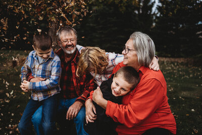 Grandma hugging grandson during fall family photoshoot