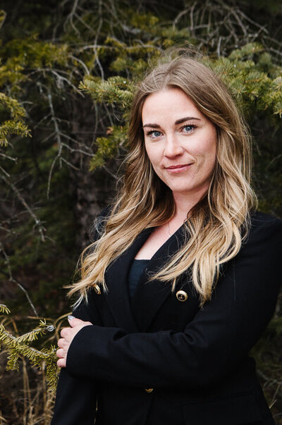 Realtor Tamara standing amidst a rustic backdrop
