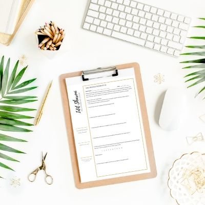 A top down view of a clipboard laying on a desk next to a mouse, keyboard, and cup of pencils. The clipboard is used by Idit Sharoni. We offer couples thearpy and marriage counseling in FL. Contact us to get in touch with a couples therapist in Florida.