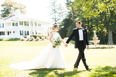 bride and groom walking in the sunshine outside at Windridge Estate