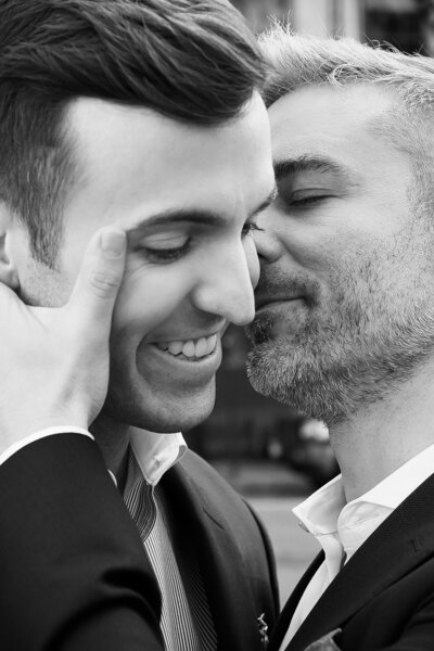 Groom kissing a groom on the cheek