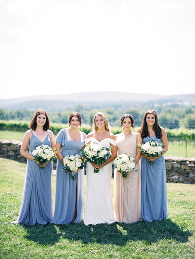 ridesmaids wearing blue celebrate with bride on her wedding day.