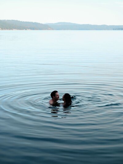 Couple swimming in a lake at their Idaho wedding
