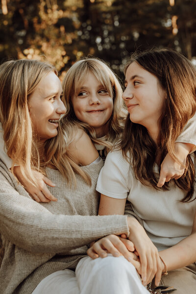 Zusjes lachen naar elkaar tijdens gezinsshoot