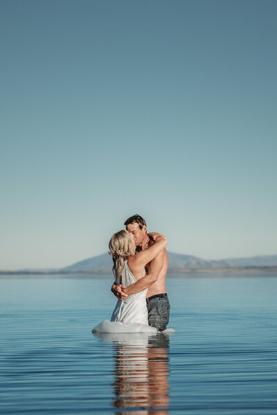 a couple standing in the water wearing their wedding clothes during their wanaka elopement