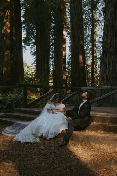 couple sitting underneath the redwoods trees, bride wearing an Anthropologie wedding dress, writing their wedding vows