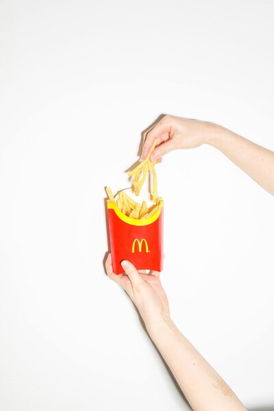 Someone taking out mcdonalds french fries from a package