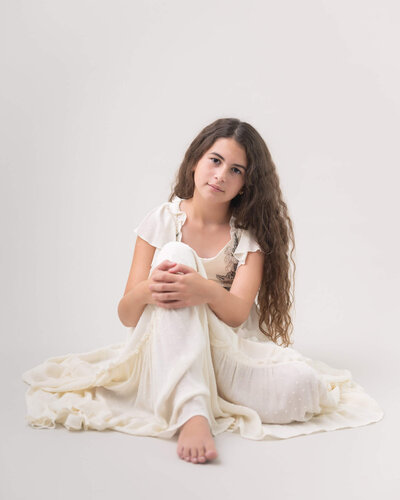 Light and airy studio portrait of a child in a client closet dress captured by Allison Amores Photography