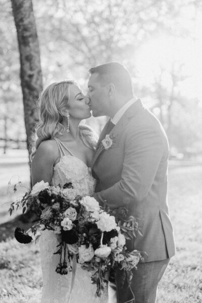 black and white photo of bride and groom kissing