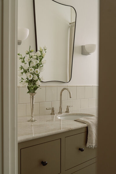 House-Franc-historical-bathroom-remodel-renovation-green-bronze-vanity-taj-mahal-quartzite-countertops-nickel-bell-flowers-fireclay-tile-crackle-tile-traditional-modern-bathroom-phylrich-bronze-knobs-warm-cozy-austin-texas